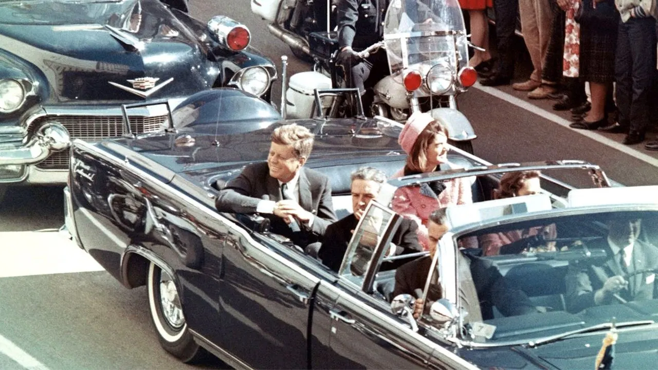 JFK Revisited: Through The Looking Glass backdrop